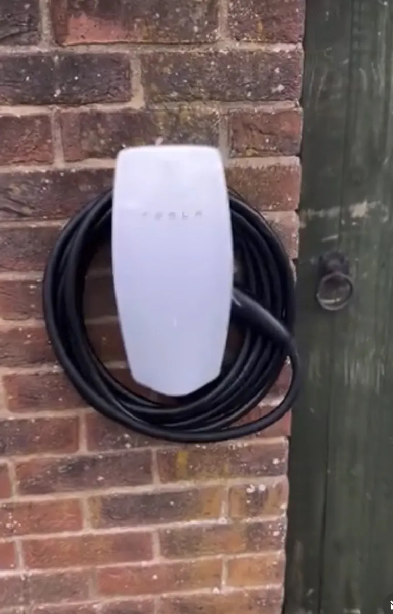 Tesla Wall Connector EV charger installed on a house wall